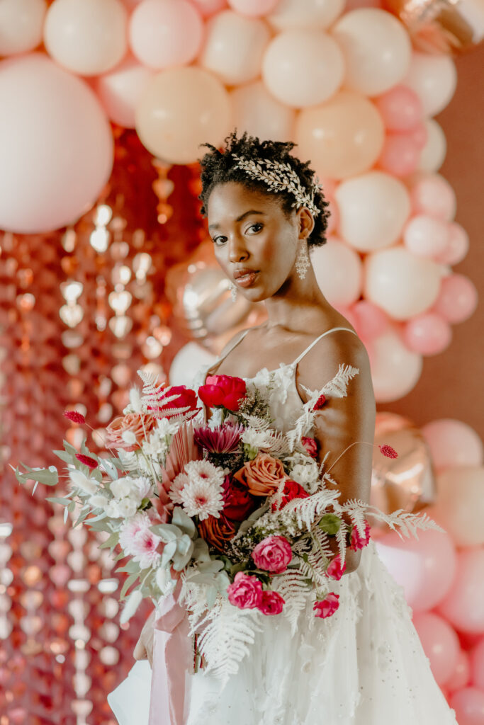 Neferttiti modeling a bridal gown and holding a bouquet in a Valentine’s editorial