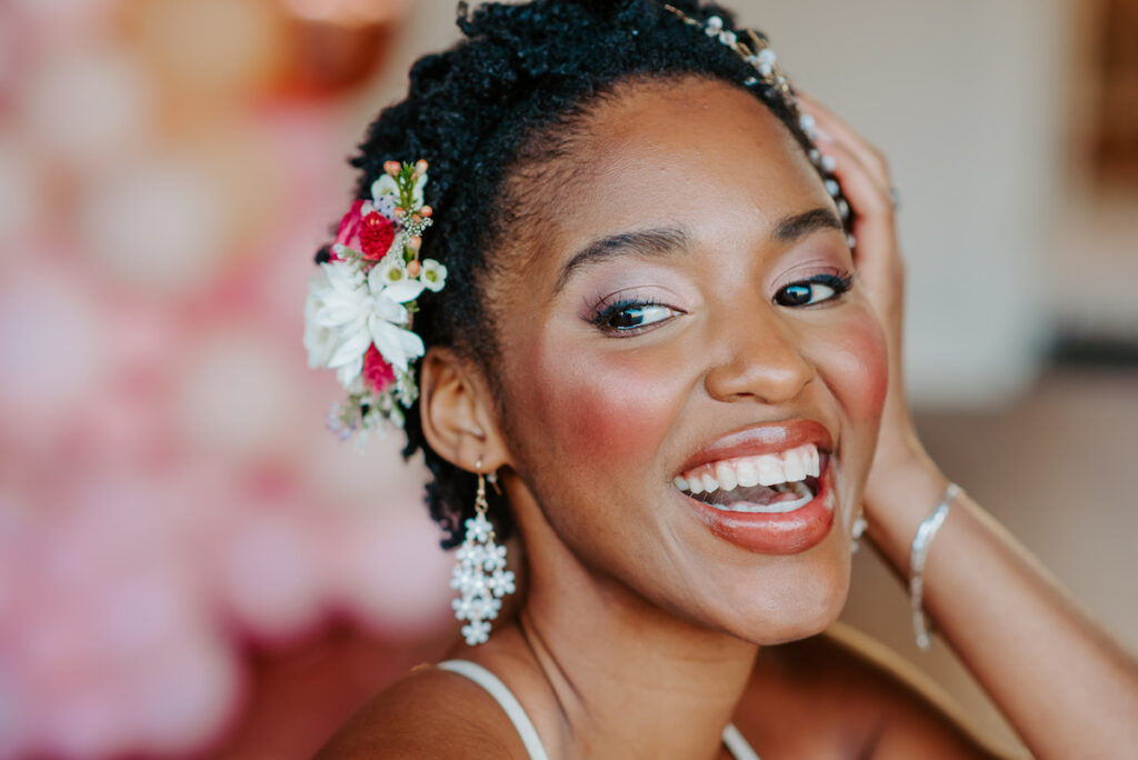 Neferttiti smiling with flowers in her hair in a bridal editorial close-up
